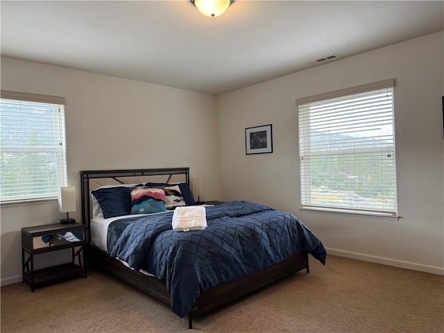 bedroom with carpet floors, visible vents, and baseboards