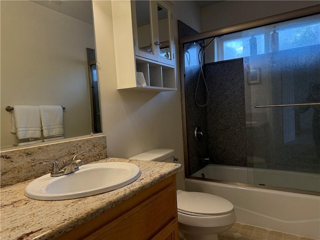 bathroom featuring combined bath / shower with glass door, vanity, and toilet