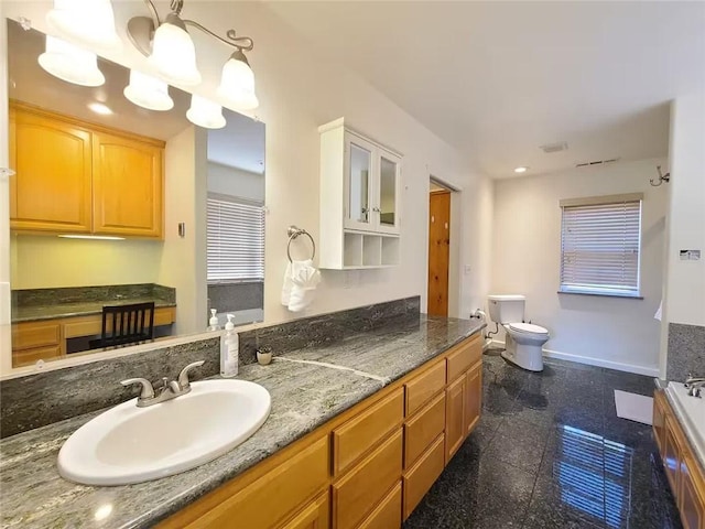 bathroom with toilet, granite finish floor, vanity, and baseboards