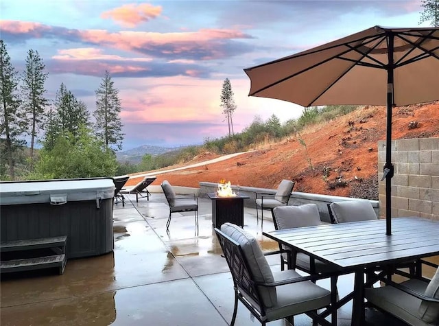 patio terrace at dusk featuring a fire pit and a mountain view