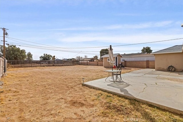 view of yard with a storage shed and a patio area