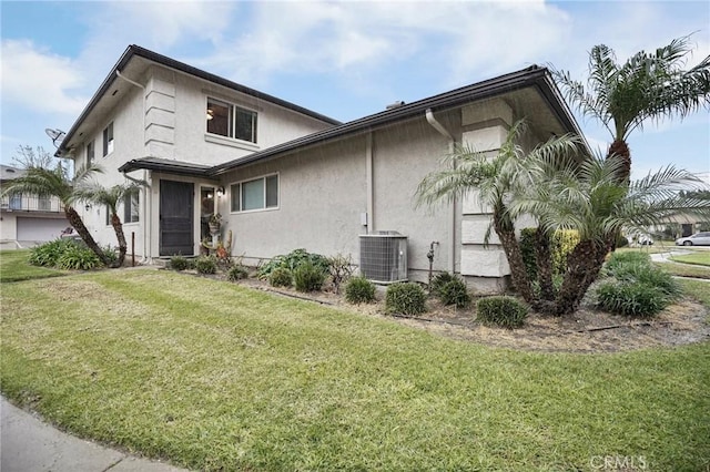 view of front of home featuring cooling unit and a front lawn