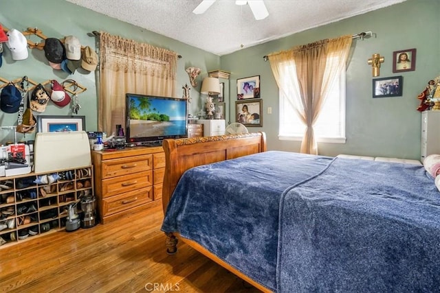 bedroom with a textured ceiling, ceiling fan, and wood-type flooring