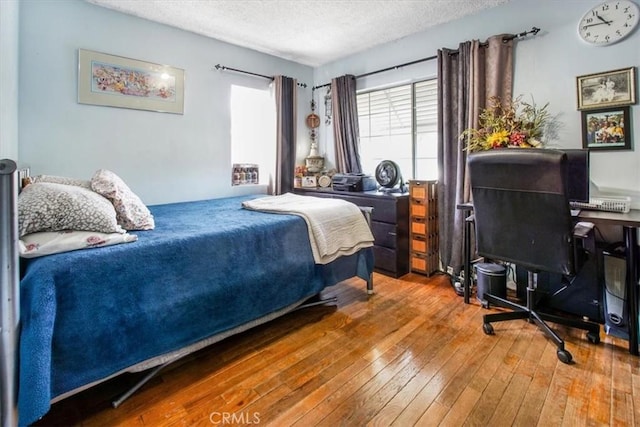 bedroom with hardwood / wood-style flooring and a textured ceiling