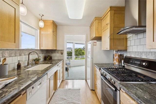1141 Green Oaks Dr, Los Osos, CA 93402 - kitchen with stainless steel gas range oven, wall chimney range hood, white dishwasher, a sink, and light wood finished floors