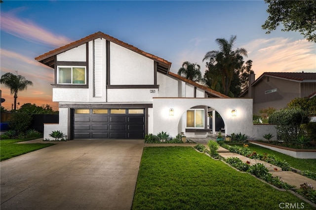 view of front of home with a yard and a garage