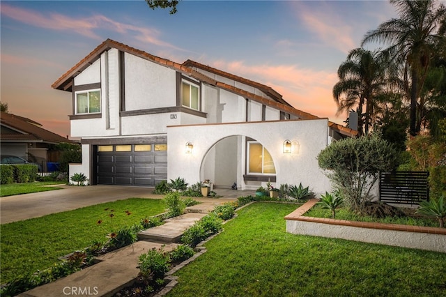 view of front of house with a garage and a lawn