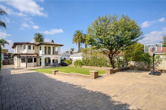 view of front of home featuring a patio and a front lawn