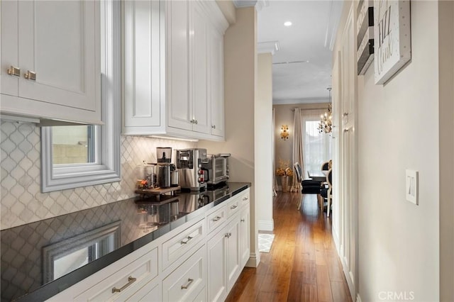 bar with white cabinets, pendant lighting, backsplash, and dark hardwood / wood-style floors