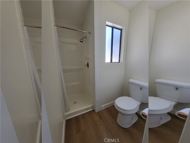 bathroom featuring hardwood / wood-style floors, a tile shower, and toilet