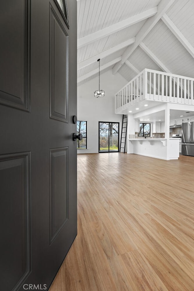 living room with light wood-type flooring, high vaulted ceiling, beamed ceiling, and wood ceiling