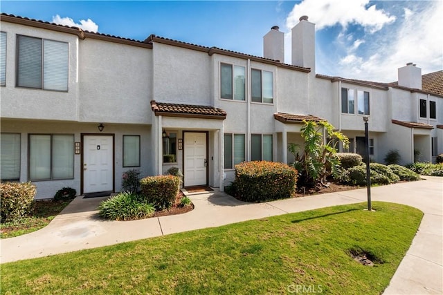 townhome / multi-family property featuring a front yard