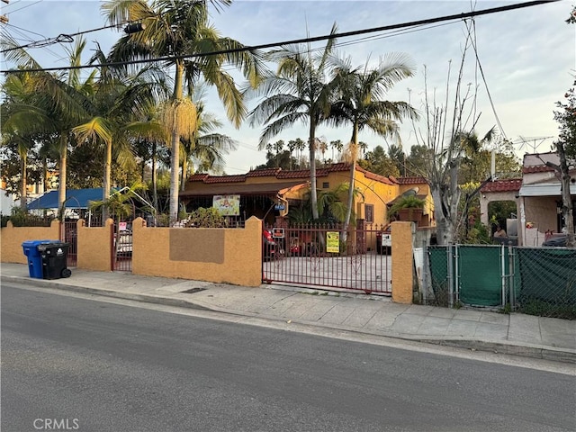 view of front of home with a fenced front yard, a gate, and stucco siding