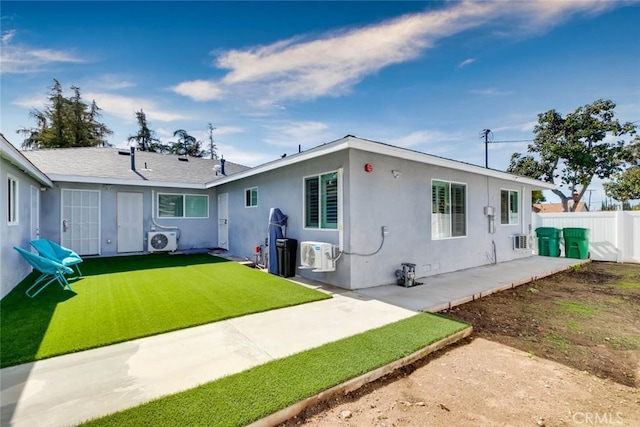 view of front of property featuring ac unit, a front yard, and a patio area