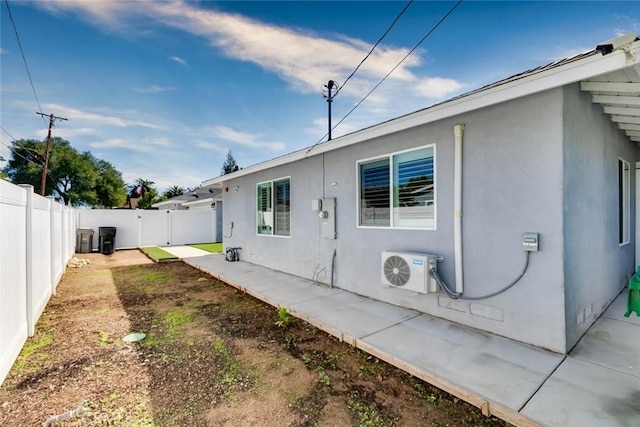 view of side of property with a patio and ac unit