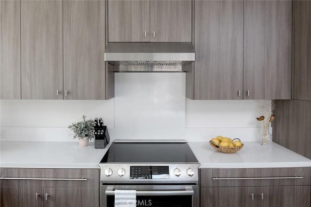 kitchen with electric range and wall chimney range hood