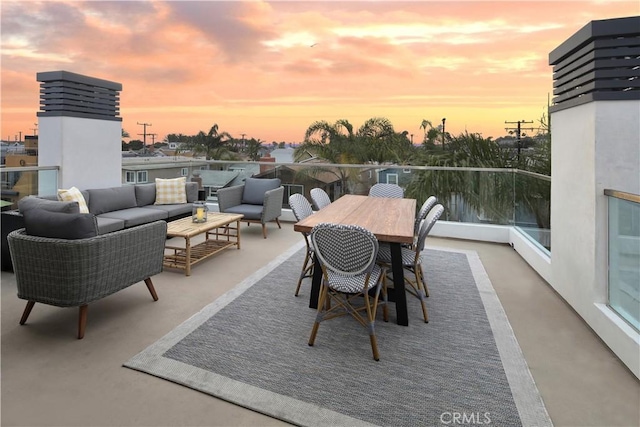 patio terrace at dusk with a balcony and an outdoor hangout area