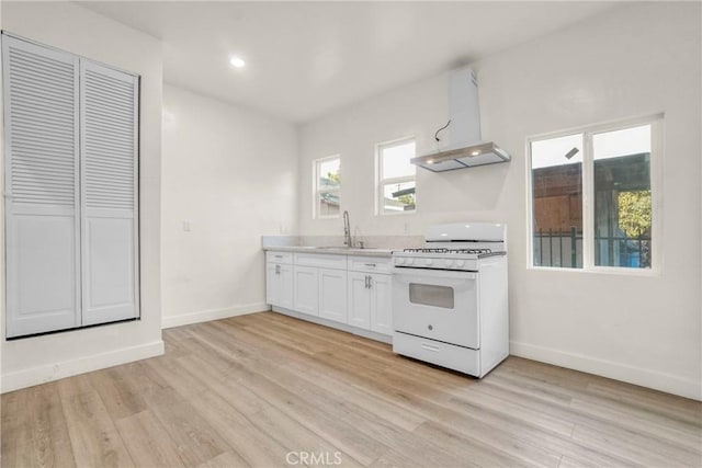 3438 Mckinley Ave, Los Angeles, CA 90011 - kitchen with a sink, baseboards, white range with gas stovetop, and wall chimney exhaust hood