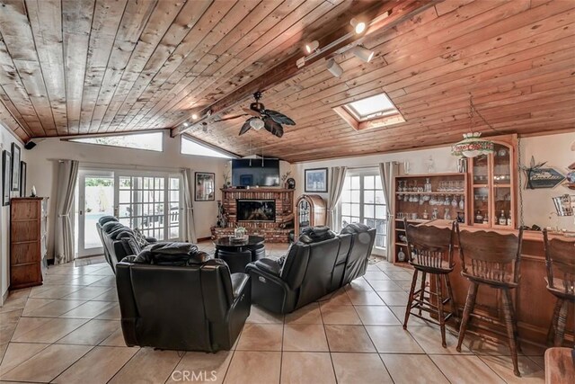 3067 Trinity Dr, Costa Mesa, CA 92626 - living room featuring a ceiling fan, lofted ceiling with skylight, light tile patterned flooring, a healthy amount of sunlight, and a brick fireplace