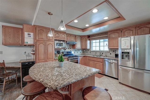3067 Trinity Dr, Costa Mesa, CA 92626 - kitchen with a kitchen breakfast bar, under cabinet range hood, a tray ceiling, a sink, and appliances with stainless steel finishes
