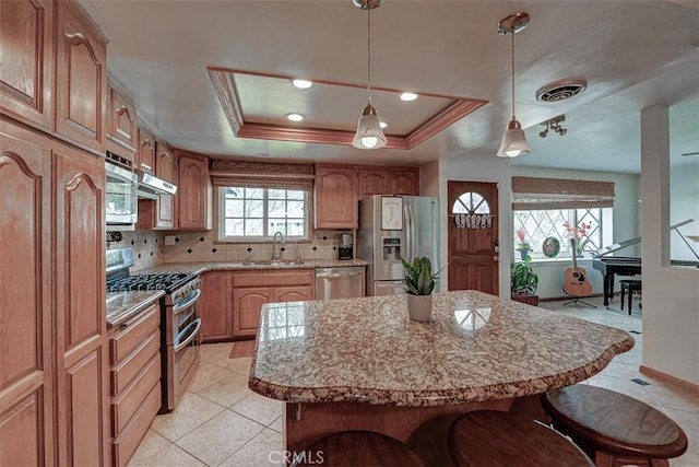 3067 Trinity Dr, Costa Mesa, CA 92626 - kitchen featuring a sink, decorative backsplash, a breakfast bar area, stainless steel appliances, and under cabinet range hood