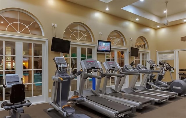 gym with a high ceiling, visible vents, and recessed lighting