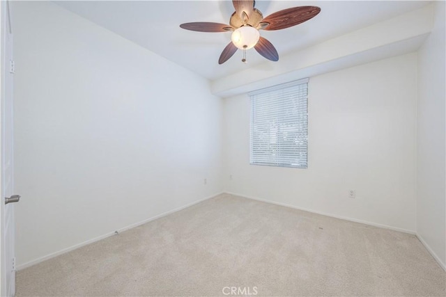 empty room with carpet flooring, a ceiling fan, and baseboards