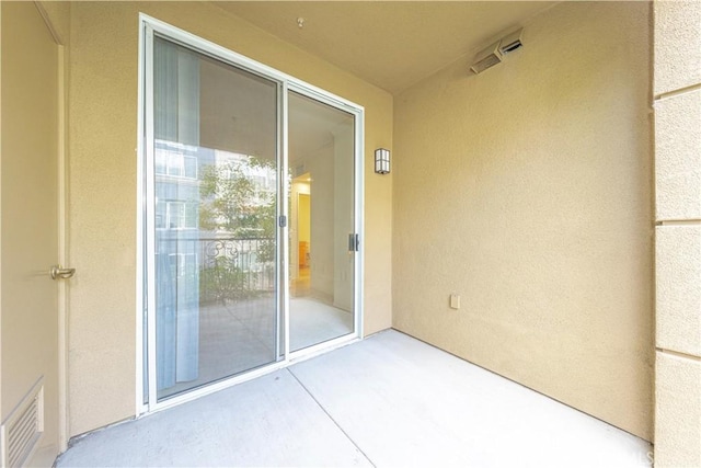 view of exterior entry featuring visible vents and stucco siding