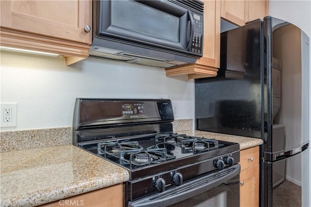 kitchen featuring arched walkways, light brown cabinets, light countertops, and black appliances