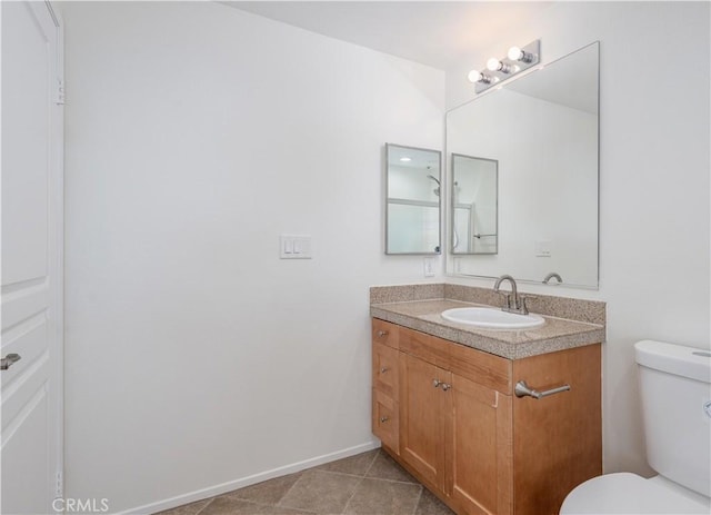 half bathroom with tile patterned flooring, baseboards, vanity, and toilet