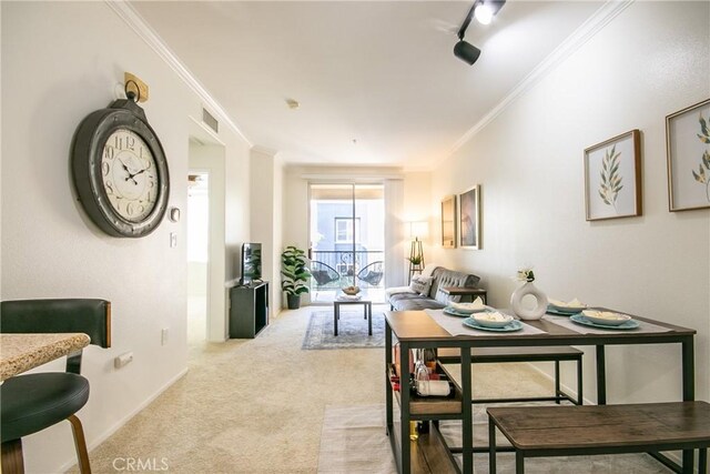 dining area featuring light carpet, visible vents, baseboards, ornamental molding, and rail lighting