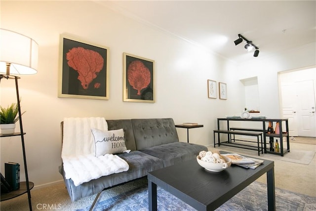 carpeted living room featuring track lighting, baseboards, and crown molding