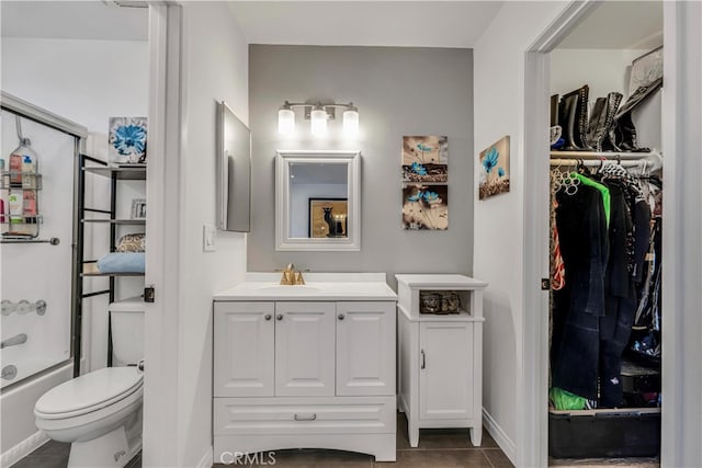 full bathroom with toilet, tile patterned floors, combined bath / shower with glass door, and vanity