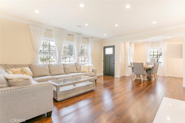 living room featuring hardwood / wood-style flooring, crown molding, and a wealth of natural light