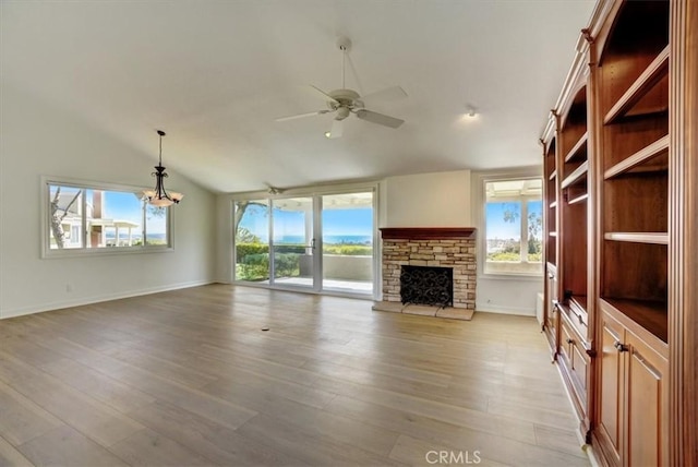 unfurnished living room with a wealth of natural light, a fireplace, and light wood-style flooring