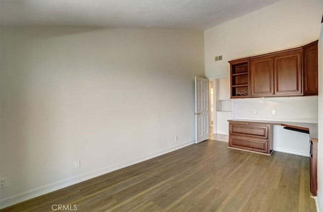 kitchen with dark wood-type flooring, visible vents, baseboards, light countertops, and open shelves