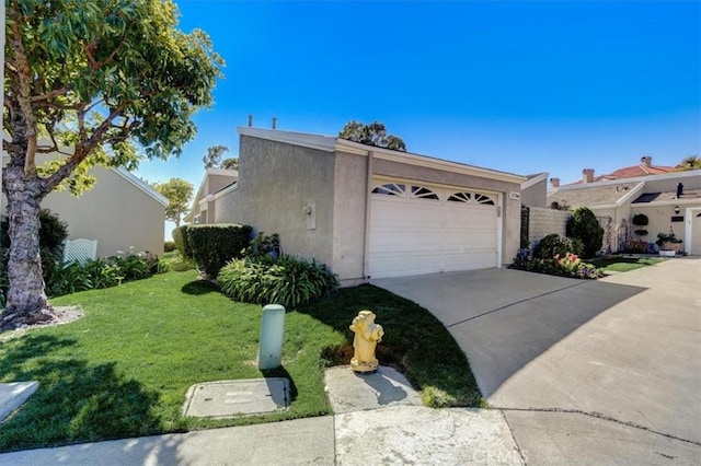 view of side of property with driveway, a yard, an attached garage, and stucco siding