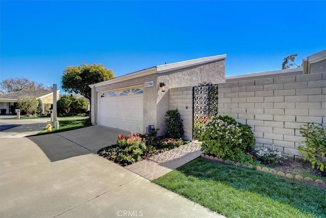 exterior space with an attached garage, concrete driveway, and stucco siding