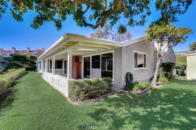 view of front of home with a front lawn and stucco siding