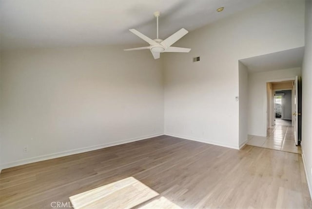 unfurnished room featuring baseboards, visible vents, a ceiling fan, and light wood-style floors