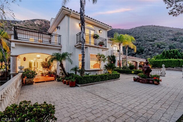 27 Round Up Rd, Bell Canyon, CA 91307 - rear view of property featuring a balcony, stucco siding, a mountain view, and french doors