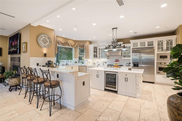 27 Round Up Rd, Bell Canyon, CA 91307 - kitchen with wine cooler, built in appliances, stone tile floors, light countertops, and recessed lighting