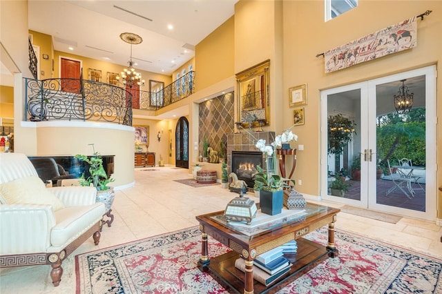 27 Round Up Rd, Bell Canyon, CA 91307 - tiled living room with a towering ceiling, a chandelier, a lit fireplace, french doors, and baseboards