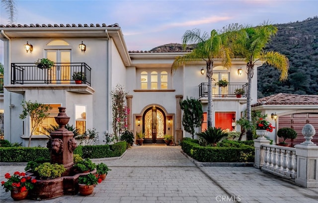 mediterranean / spanish home with french doors and a balcony