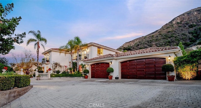 mediterranean / spanish home featuring a balcony, a garage, and a mountain view