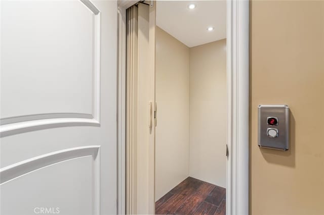 interior details featuring elevator and wood-type flooring