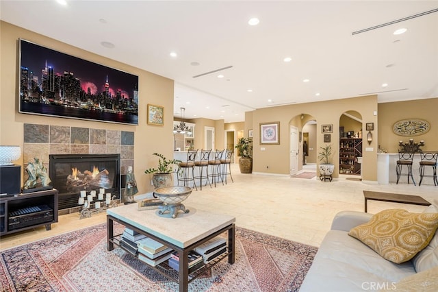 27 Round Up Rd, Bell Canyon, CA 91307 - living room with arched walkways, a tiled fireplace, recessed lighting, and baseboards