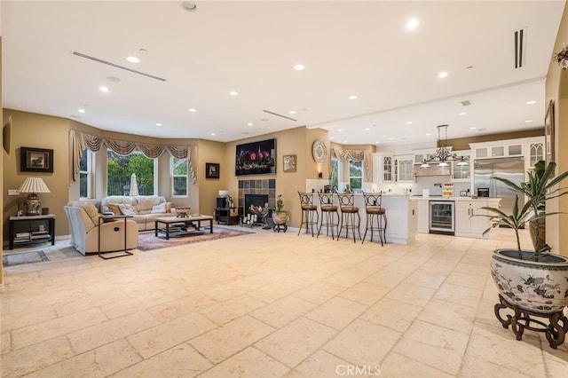 27 Round Up Rd, Bell Canyon, CA 91307 - living area with wine cooler, stone tile flooring, recessed lighting, a fireplace, and bar area