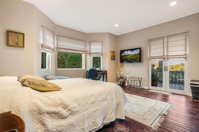 bedroom featuring multiple windows, access to exterior, and dark hardwood / wood-style flooring