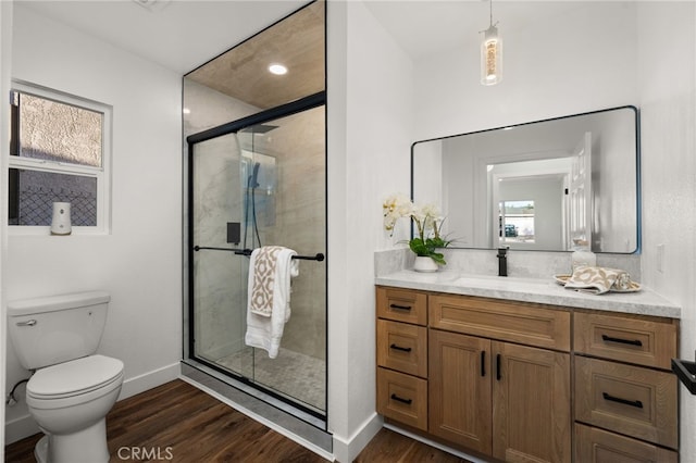 bathroom with vanity, a shower stall, toilet, and wood finished floors